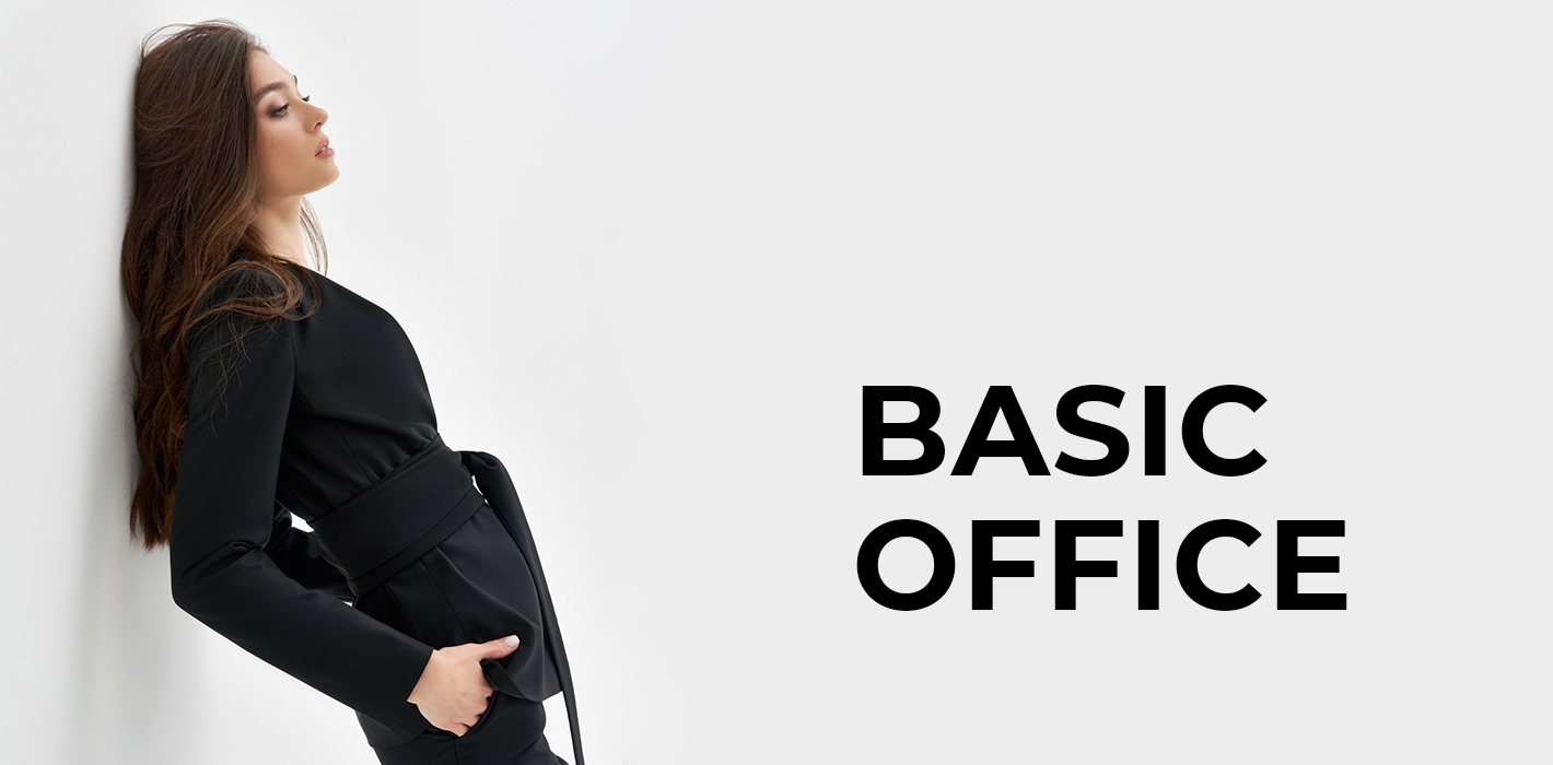 Дівчина в чорному жакеті з поясом біля стіни, поруч напис Basic Office