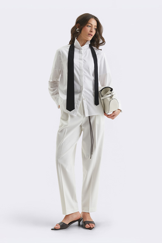 Елегантний жіночий образ Natali Bolgar з білою блузою та широкими штанами. Ідеально для офісу чи весняного ділового стилю.