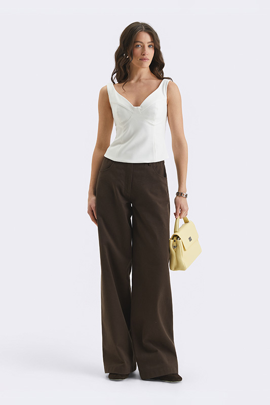 Жіночий елегантний образ Natali Bolgar з білим топом-бюстьє та широкими коричневими штанами. Стильний варіант для побачення.
