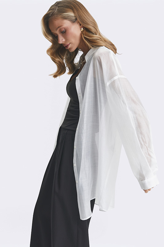 Жіночий образ Natali Bolgar: стильна біла прозора сорочка оверсайз та чорні широкі штани для літнього сезону.