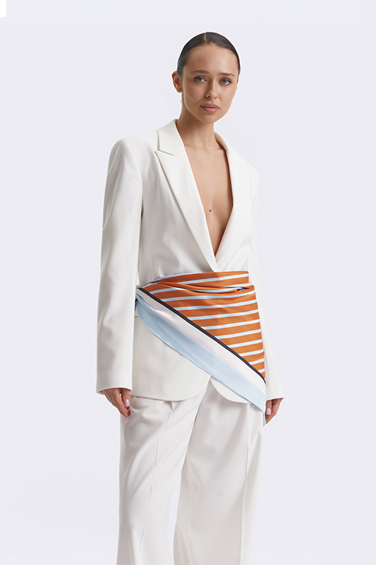 An elegant white Natali Bolgar jacket and trousers, finished with a striped scarf, for a refined spring look.