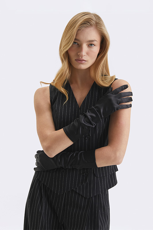 An elegant Natali Bolgar look: a black pinstriped vest and trousers finished with long satin gloves. The perfect choice for a business style.