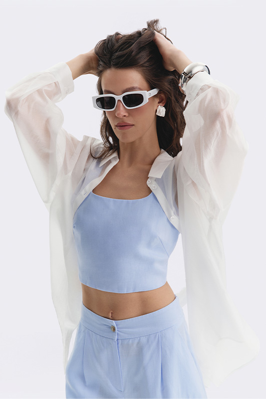 A summer look from Natali Bolgar with a pastel blue top, trousers, and a sheer white shirt. The perfect choice.