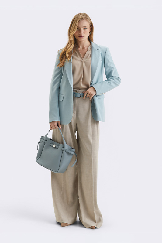 A spring look from Natali Bolgar: a light-blue jacket, wide beige trousers, and a blouse come together for an elegant business style.
