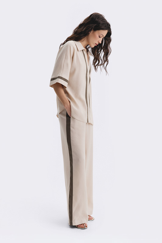 Natali Bolgar look: a women's pastel shirt and wide trousers with contrast stripes. Versatile style and comfort for every day.
