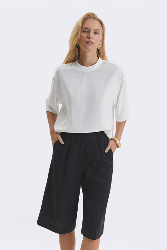 Stylish women's everyday look by Natali Bolgar: a white short-sleeve blouse and comfortable black culottes for comfort at home and beyond.