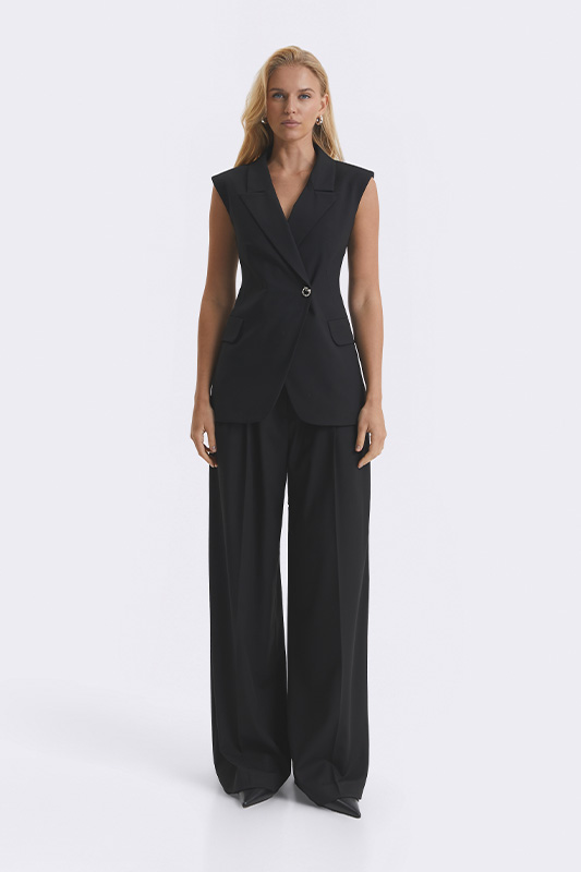 A graceful women's look from Natali Bolgar: a sleeveless black jacket with a belt and wide trousers. A perfect office and business style for spring.