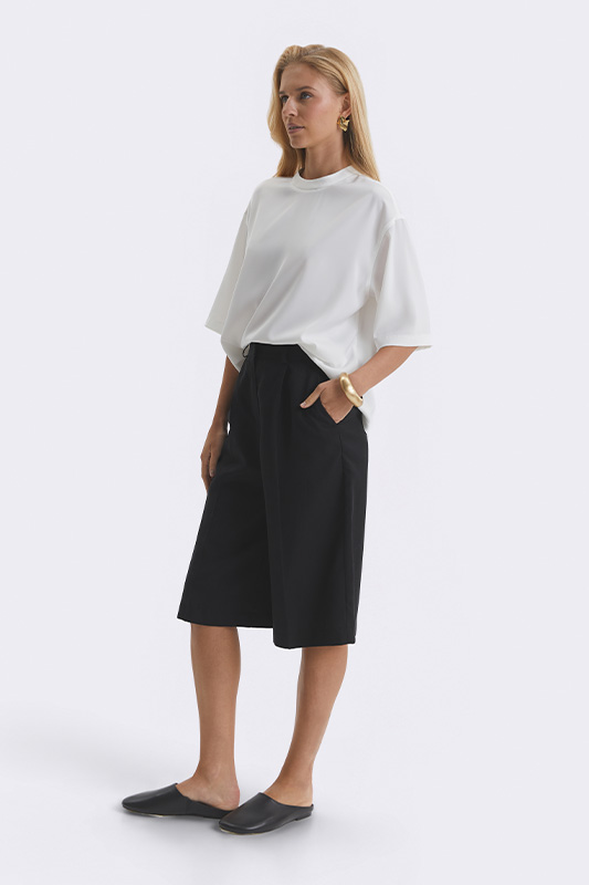 A casual women's look from Natali Bolgar: a loose white t-shirt and black culotte shorts. A comfortable summer style for the city and leisure.