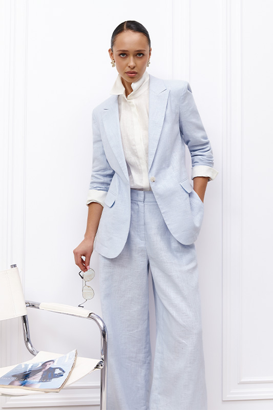 A spring business look from Natali Bolgar: a women's jacket and wide pastel blue trousers, paired with a white shirt.