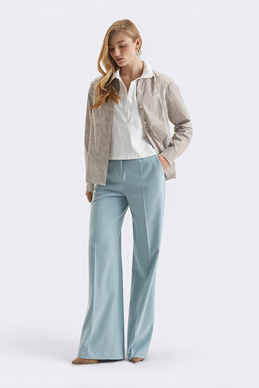 A spring look from Natali Bolgar: light blue palazzo trousers, a white polo blouse and a stylish striped jacket.