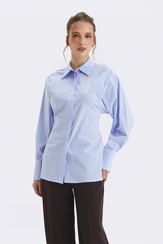 A women's blue striped shirt from Natali Bolgar paired with trousers. A modern office style.