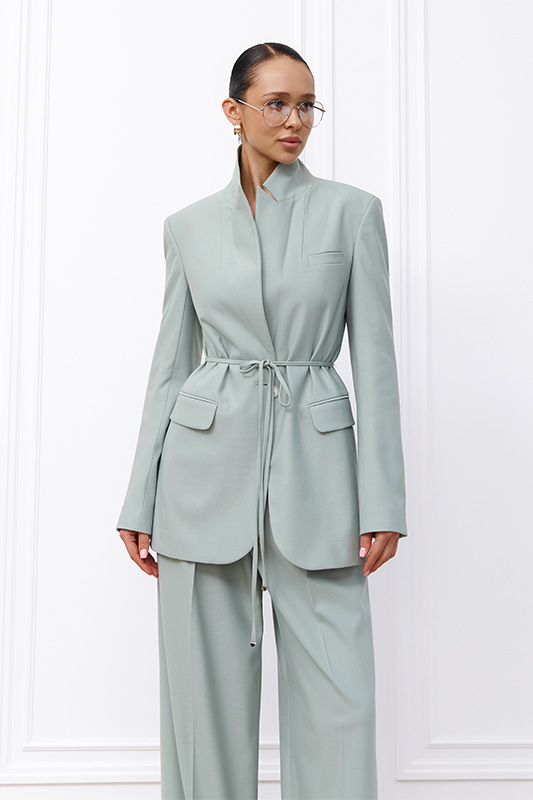 An elegant Natali Bolgar women's blazer in pastel green and trousers for a stylish spring business look.