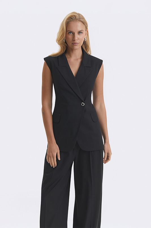 Black Natali Bolgar sleeveless women's jacket paired with wide trousers. An elegant look for spring.