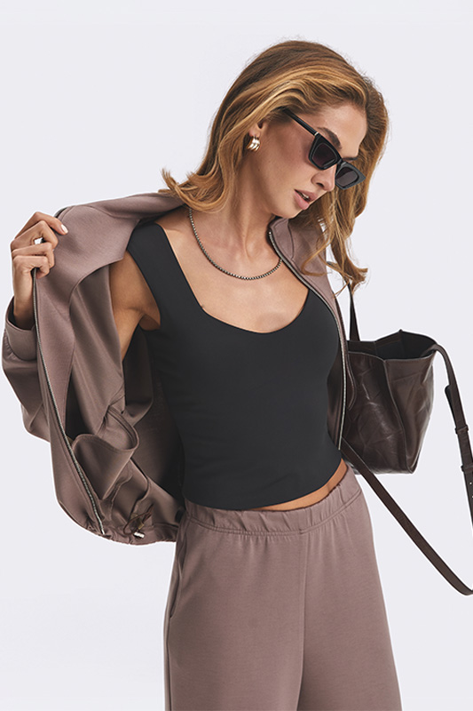 Brown Natali Bolgar women's bomber jacket paired with a black top. A stylish spring look for active women.