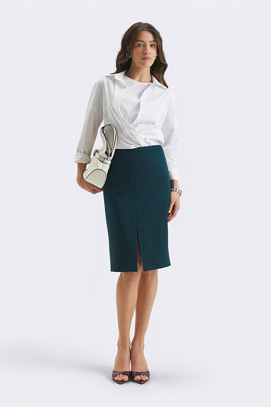 A feminine, elegant look from Natali Bolgar: a white shirt and a dark teal midi skirt with a slit, perfect for the office.