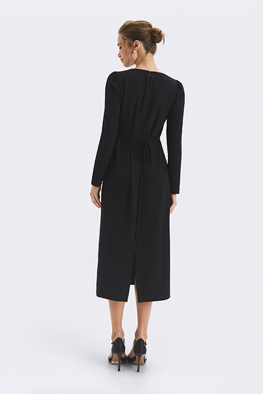 A black women's midi dress by Natali Bolgar with long sleeves and waist ties, combining freedom of movement with a graphic silhouette.