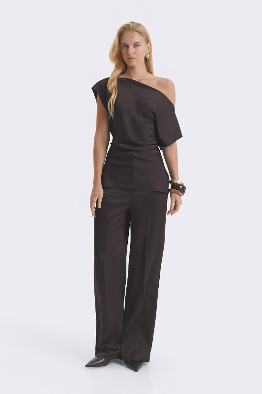 An elegant Natali Bolgar women's evening look made up of a dressy one-sleeve top and wide chocolate-toned trousers.