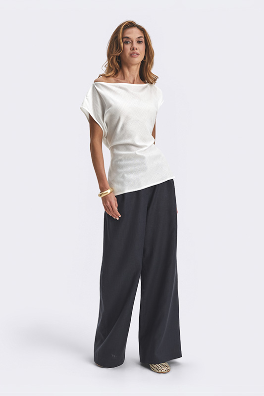 A women's summer look by Natali Bolgar: a loose white top with a boat neckline and comfortable wide trousers for the modern woman.