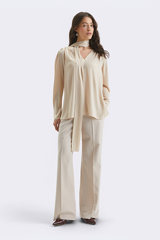 An elegant Natali Bolgar women's look for spring: a beige blouse with a tie neck and wide, loose-fit trousers for everyday comfort.