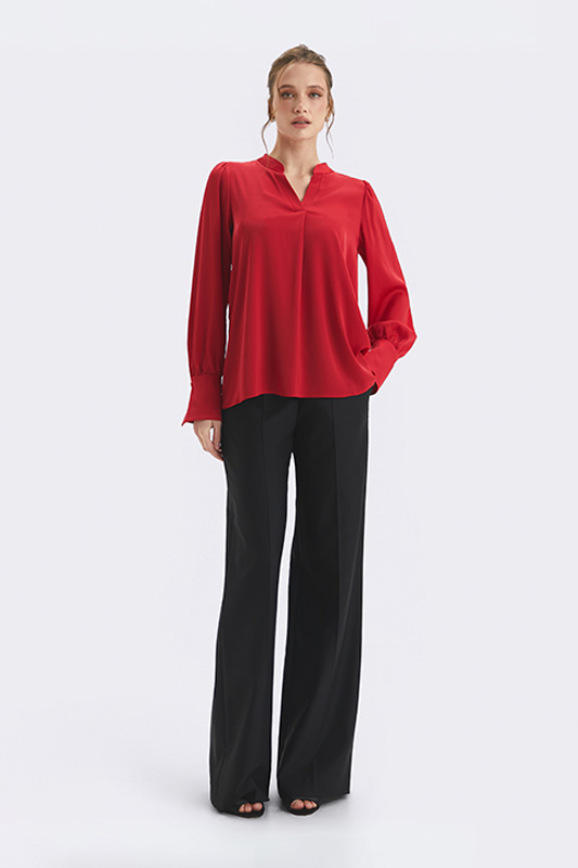 An elegant Natali Bolgar women's look: a loose red blouse and wide black palazzo trousers for spring, combining freedom with structure.